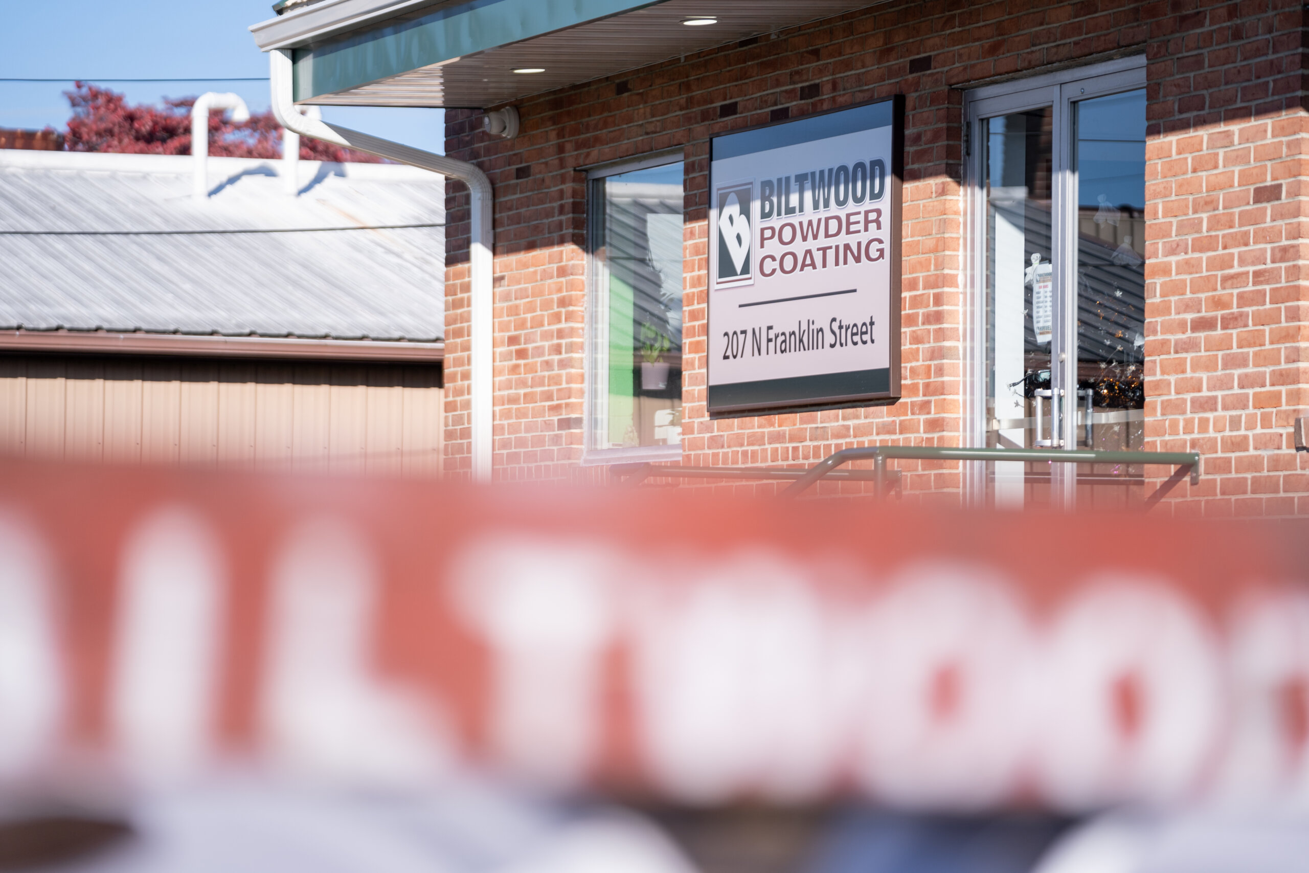 Exterior view of Biltwood Powder Coating building with company sign at 207 N Franklin Street.
